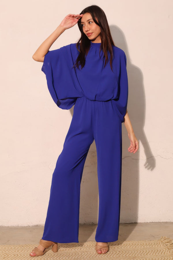 Woman in royal blue wide-leg jumpsuit with puff sleeves, stylish modern fashion for everyday wear