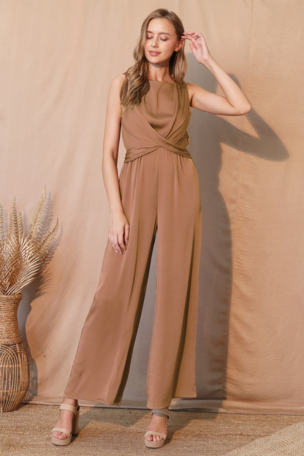 Elegant sleeveless jumpsuit with wide legs and draped neckline, styled for modern everyday fashion.