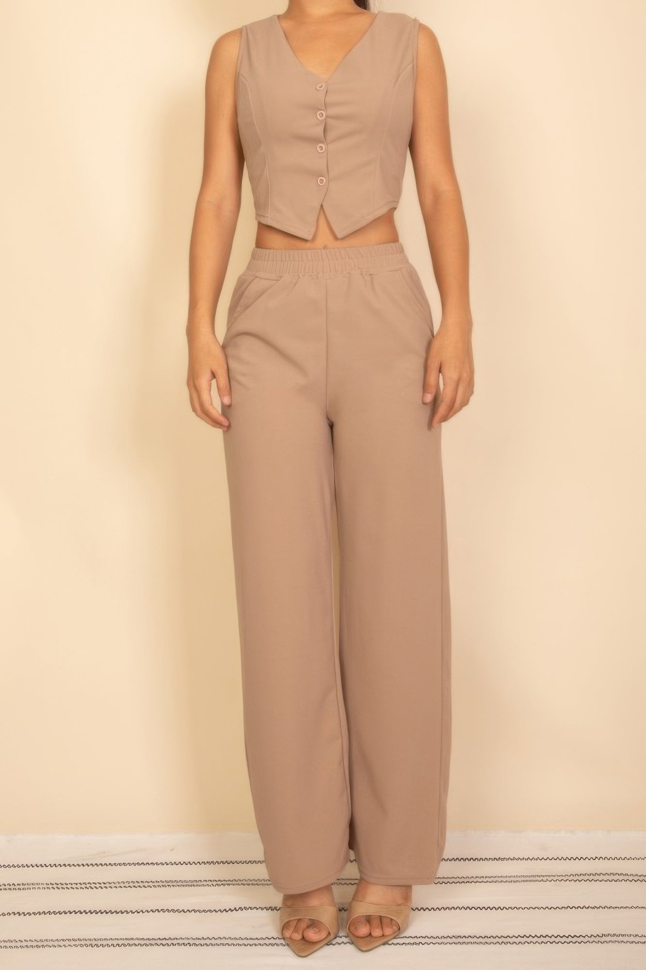 Beige sleeveless button-front crop top with matching wide-leg pants for modern women's fashion