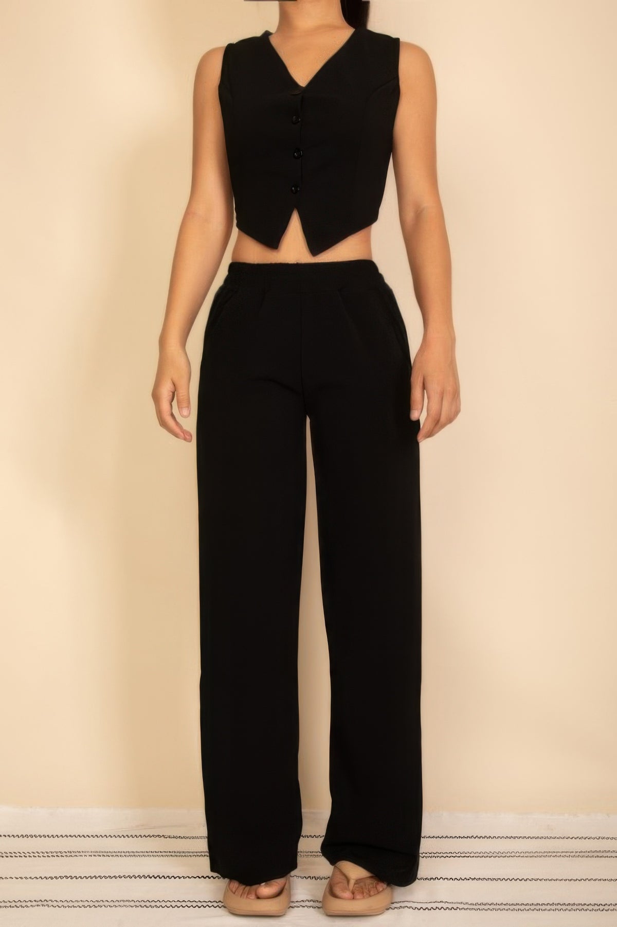 Black sleeveless cropped top with buttons and wide-leg pants for women's modern fashion