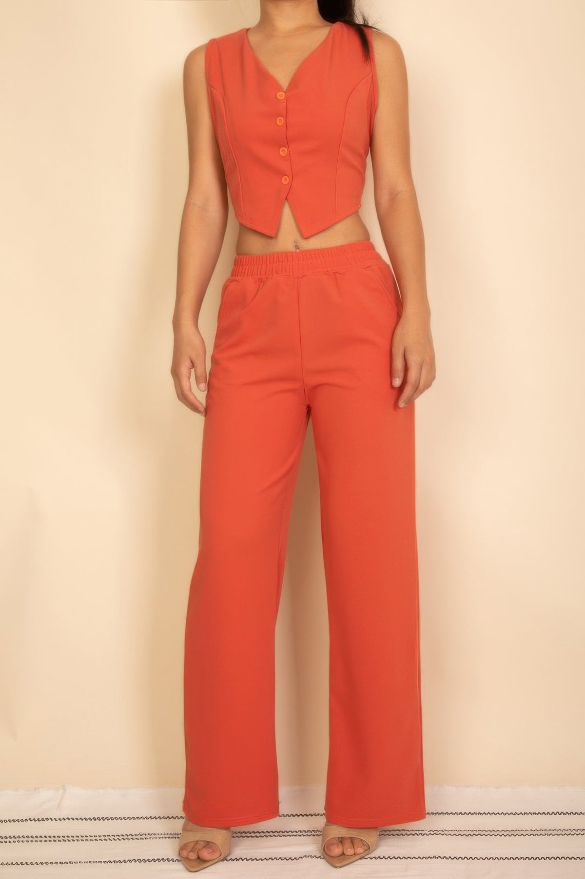 Coral sleeveless button-front crop top with matching wide-leg pants, stylish women's outfit
