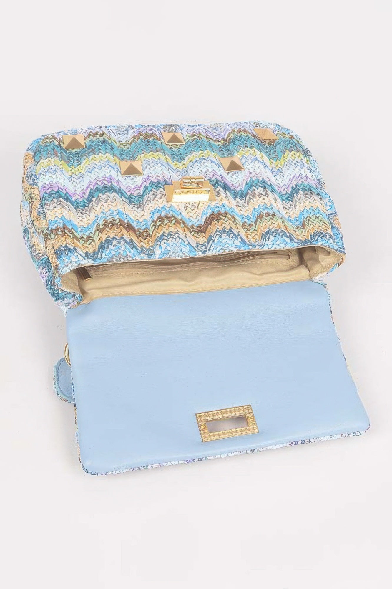 Light blue clutch with colorful zigzag print and gold studs, open to show interior