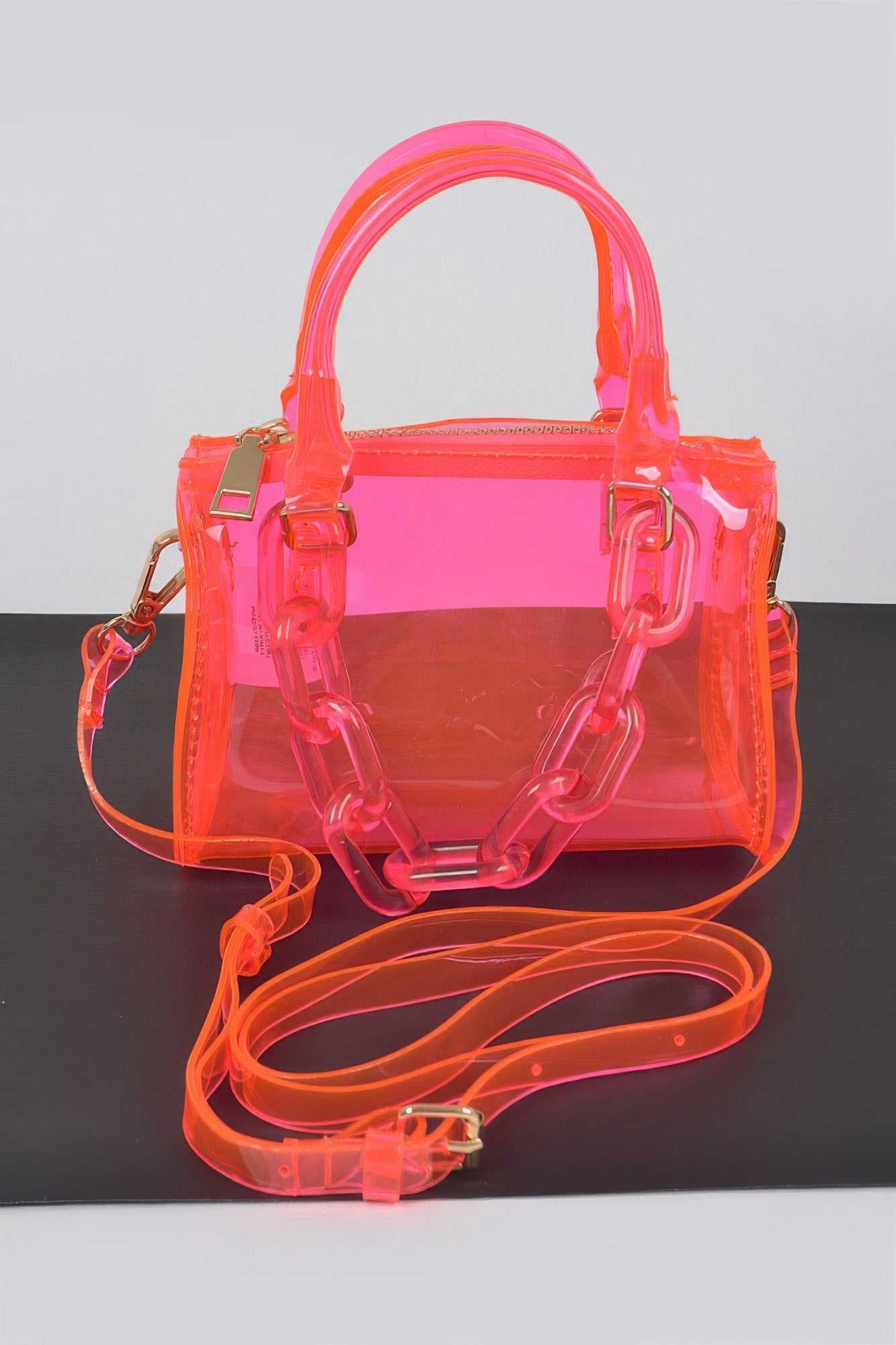 Neon pink transparent handbag with chunky chain strap and top handle, stylish women's fashion accessory