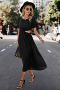 Woman in black cutout midi dress with puff sleeves, hat, and heels for stylish streetwear