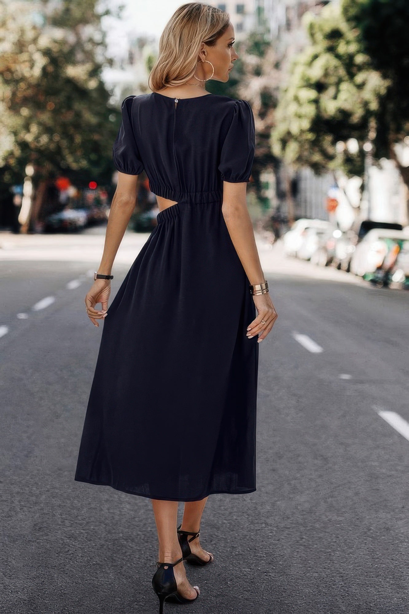 Navy blue midi dress with puff sleeves and back cutout, styled for elegant everyday wear