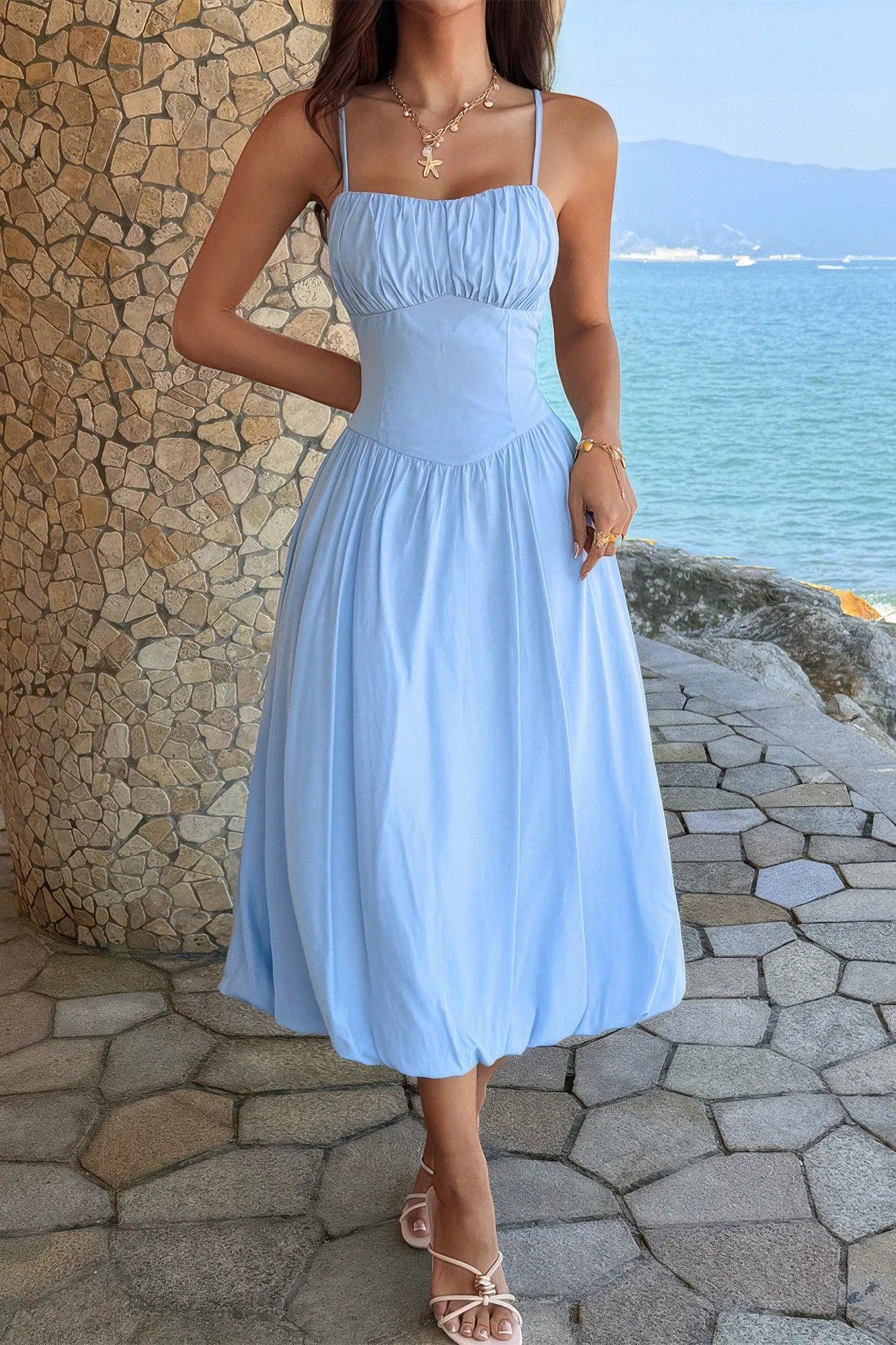 Light blue midi dress with spaghetti straps, perfect for beachside elegance and summer style.